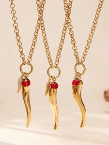Detailed close-up of 18k gold-plated necklaces with chili pendant and ladybug charm