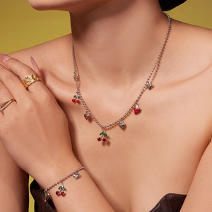 Parure de bijoux cerise et fraise avec collier, bracelet et bagues portés par un mannequin