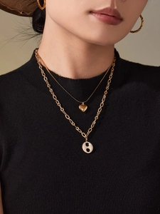 Gros plan sur l'ensemble collier doré double épaisseur avec pendentif cœur sur mannequin