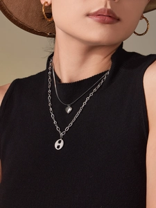 Détail du collier double rang avec cœur et zircon H et boucles d'oreilles créoles