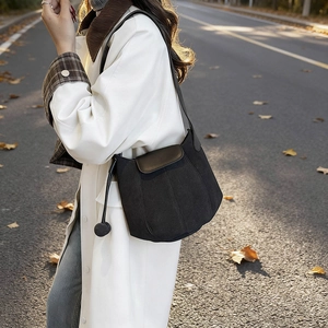 Sac seau citrouille mat avec rabat en cuir marron dans un décor de rue automnal