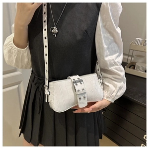Detailed view of white crocodile pattern shoulder bag with decorative silver buckle
