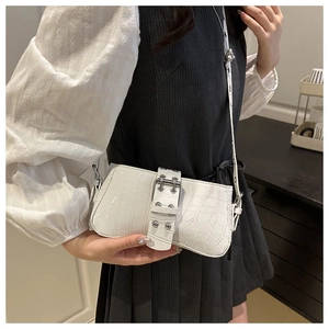 Détail du sac baguette blanc à motif crocodile avec boucle en métal et bandoulière imprimée