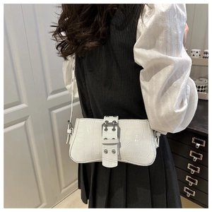 Détail d'un sac baguette blanc motif crocodile avec boucles argentées et rivets