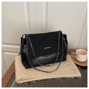 Detail of silver chain strap and white FASHION & BAGS lettering on black tote bag