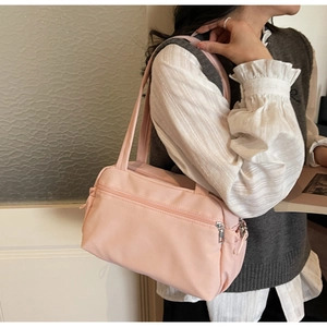 Light pink minimalist nylon tote bag with multiple pockets shown on model for daily commute