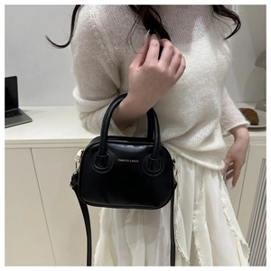 Detail view of black petite PU handbag with golden lettering and adjustable shoulder strap