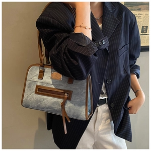 Detail der Vintage-Jeans-Tote-Bag mit braunem Lederbesatz und silbernem Reißverschluss