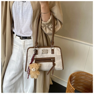 Detail der Retro-Einkaufstasche mit strukturiertem Stoff, braunem Rand und Plüschbär