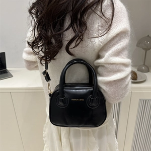 Sac bandoulière rond rétro en cuir noir avec lettrage doré et poignée élégante