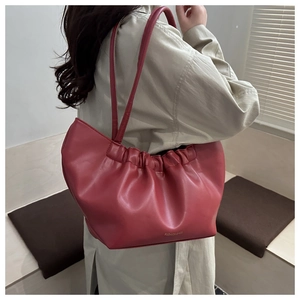 Close-up of pleated cloud shoulder bag in coral red with Fashion Bags lettering