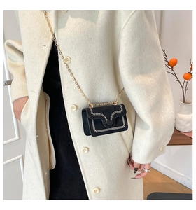 Mini black suede crossbody bag with contrast white wavy stitching and gold chain