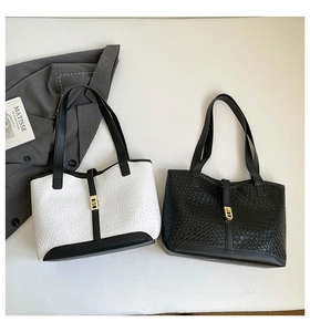 Detail of crocodile embossed tote bags with elegant gold buckle and textured leather finish