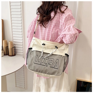 Detailed side view of off-white canvas crossbody bag with black mesh pocket and Ultra print