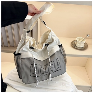 Close-up of white drawstring crossbody bag with mesh pockets and ULTRA lettering detail