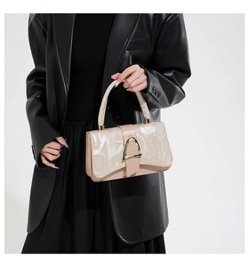 Détail du sac à main nude avec imprimé géométrique et fermoir en triangle doré