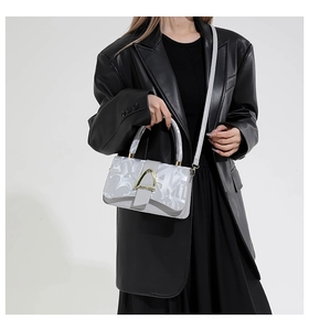 Détail d'un sac à main argenté à motifs géométriques et fermoir doré chic