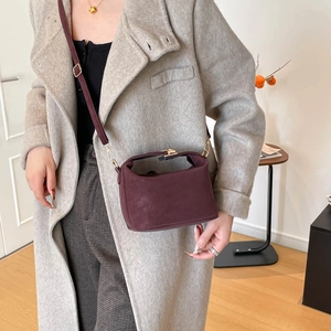 Structured deep wine red crossbody bag in matte leather finish with metal buckle detail