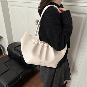Chic pleated cream shoulder bag with large capacity for women on minimalist background