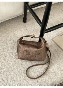 Detailed close-up of retro bronze boston bag with metallic texture on a soft carpet