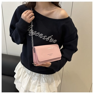 Detail view of pink glossy chain crossbody bag featuring silver hardware and polished finish