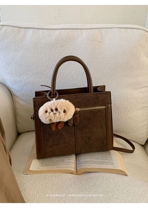 Détail du sac cabas en daim marron foncé avec poche zippée et pendentif en peluche