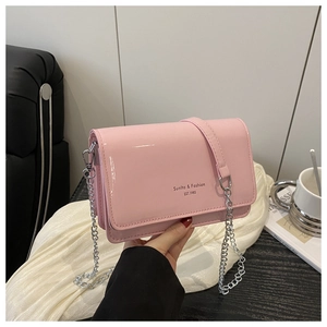 Detailed macro view of pink glossy patent leather texture and silver chain strap