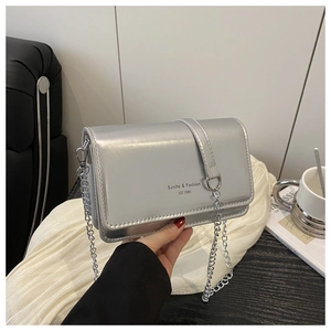 Close-up of silver chain bag with mirror finish and Sunlta brand logo detail
