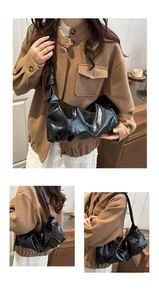 Détail du sac à bandoulière plissé noir brillant avec large sangle et style minimal