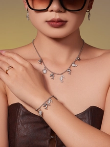 Model wearing marine themed 18k gold plated jewelry set with zircon dolphin and turtle charms