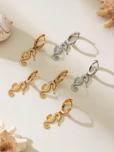 Close-up of seahorse drop earrings with pavé zircons in gold and silver plating