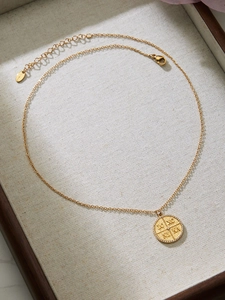 Makroaufnahme der goldenen Münzhalskette mit IC XC NI KA Gravur und filigraner O-Kette