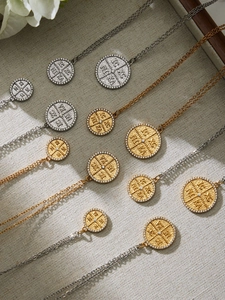 Nahaufnahme goldener und silberner Münzhalsketten mit Zirkonia und religiösen Ikonen