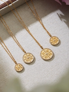 Makro-Detail von Goldmünzen-Anhängern mit IC XC NI KA-Inschrift und Zirkon-Rand