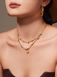 Λεπτομέρεια σετ κολιέ και σκουλαρίκια 18k με κρυστάλλινο φιόγκο και καρδιπλή καρδιά