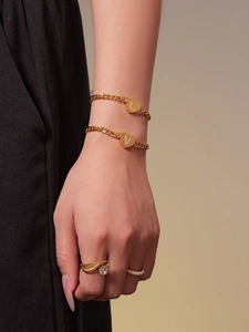 Detail von 18k Gold Herz-Initialen Armbändern mit Zirkonia-Besatz an einem Model