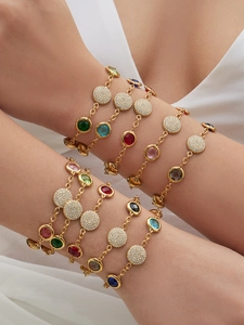 Close-up of stacked 18k gold plated bracelets featuring colorful zircon stones and diamonds