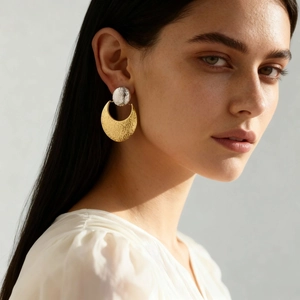 Two-tone geometric hammered stainless steel drop earrings shown on a female model