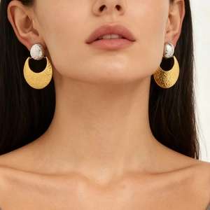 Two-tone stainless steel earrings with textured hammer finish on a female model
