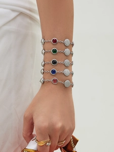 Detail showing five stainless steel bracelets with colored round zircon stones on model's wrist