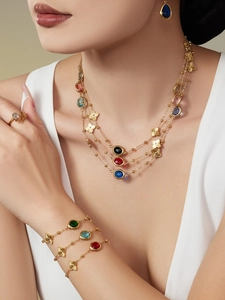 Detalle de collares dorados y conjunto de trébol con piedras preciosas de colores