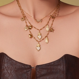 Layered 18k gold plated necklace featuring heart, bow, and religious medal pendants