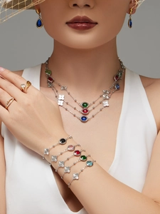 Primer plano de conjunto de joyas doradas con gemas coloridas en una modelo femenina