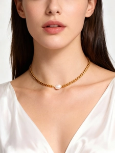Detail of a minimalist 18K gold chunky chain necklace featuring a single elegant white pearl