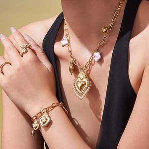Parure de bijoux dorés avec pendentifs cœur, perles et billes de céramique florales sur femme