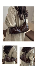 Détail du sac hobo marron foncé brillant en cuir verni avec texture plissée et bandoulière chic