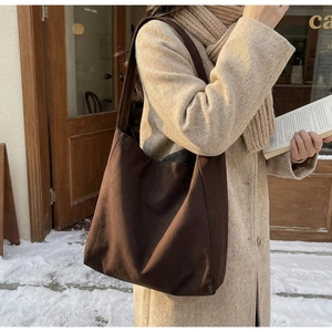 Vista outdoor di una borsa tote in tela marrone caffè con una calda finitura strutturata
