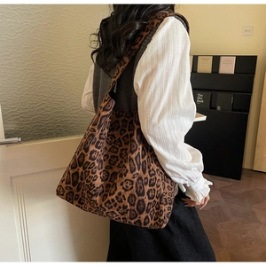 Dettaglio di una grande borsa tote in tela con stampa leopardata su una modella