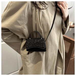 Close-up of black leopard embossed mini crossbody bag with sleek metallic hardware