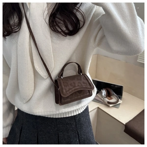 Close-up of leopard pattern embossed on dark brown faux leather mini crossbody bag